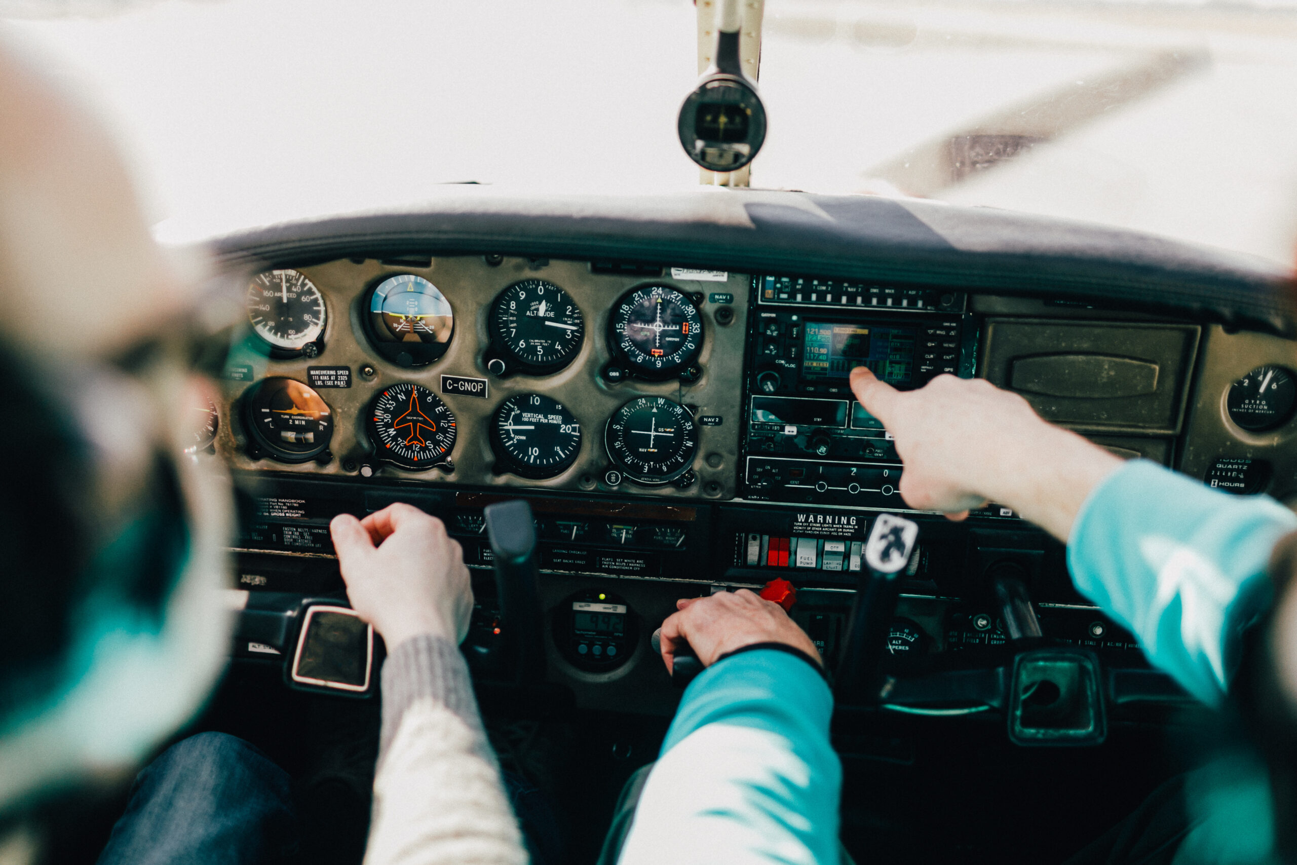 Flight instructor and student inside small Piper aircraft [Credit: Adobe Stock]