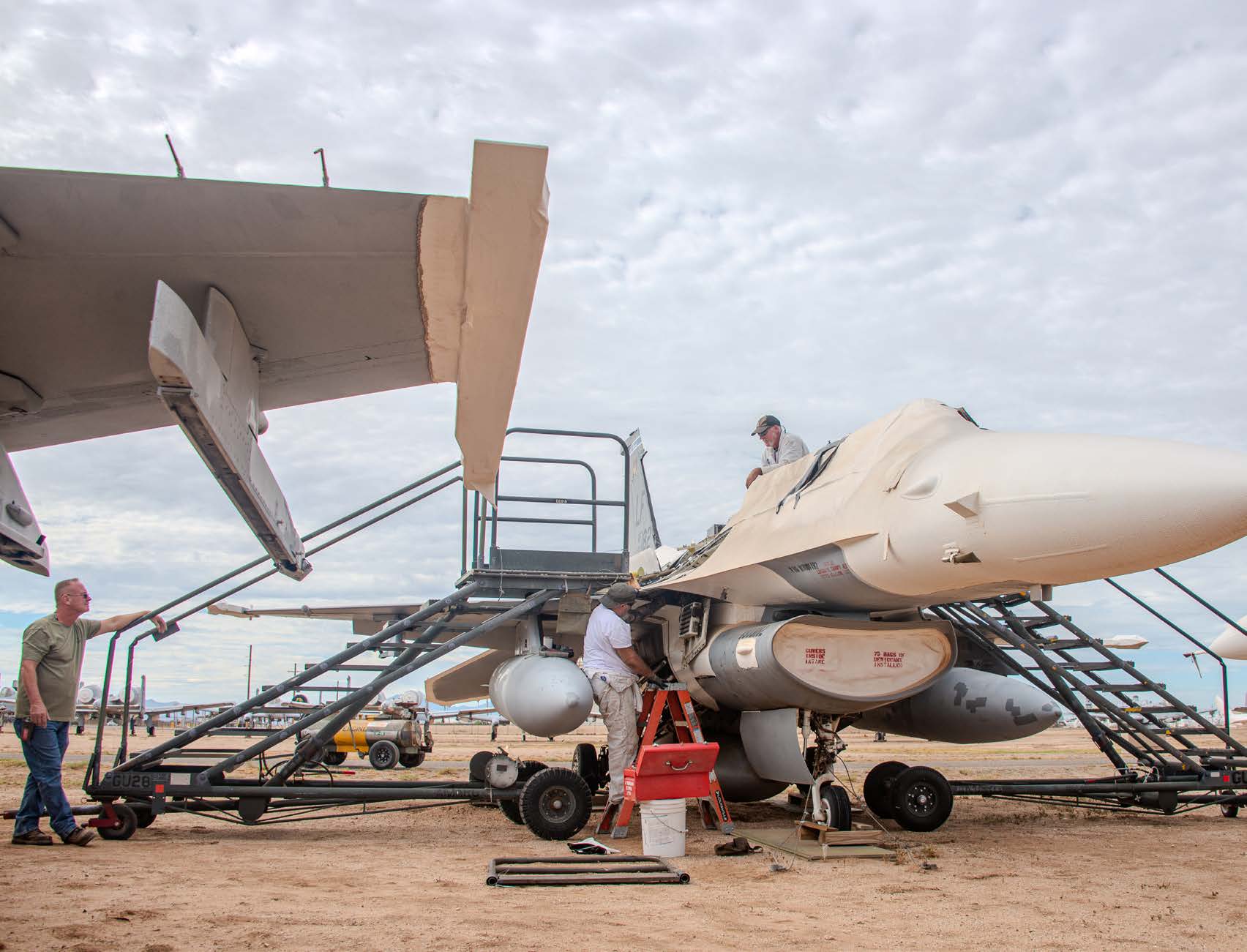 Crews prepare an F-16 for long-term storage by applying protective wrapping. [Credit: Connor O'Shea]