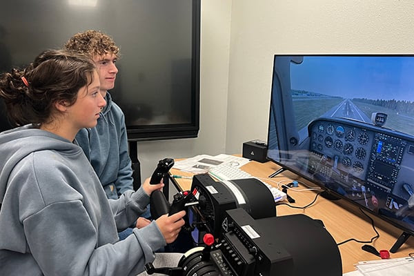 Two Peninsula School District students take the controls with a flight simulator at PSD's Aviation Academy [Credit: Peninsula School District]